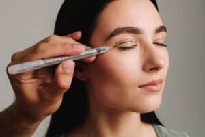 Surgeon carefully drawing marking lines on a patient’s eyelid with a marker while planning an upper blepharoplasty procedure for precise surgical results